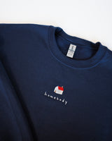 navy blue Gildan sweater with a homebody design embroidery in the upper middle chest area. The design features a house icon with the words homebody under it