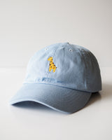 A pastel blue cap featuring our giraffe embroidery design in the center