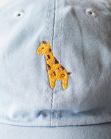 Close up of the giraffe embroidery design on the pastel blue cap