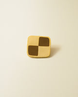 Shiny gold-colored hard enamel pin with metal butterfly clasp in the form of a checkerboard shaped cookie.