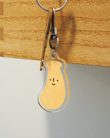 Banana with a cute smile acrylic keychain attached to a key