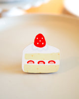 Strawberry cake slice wooden magnet displayed on a plate