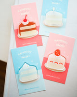 A set of all 4 different acrylic cake magnets on a white surface.